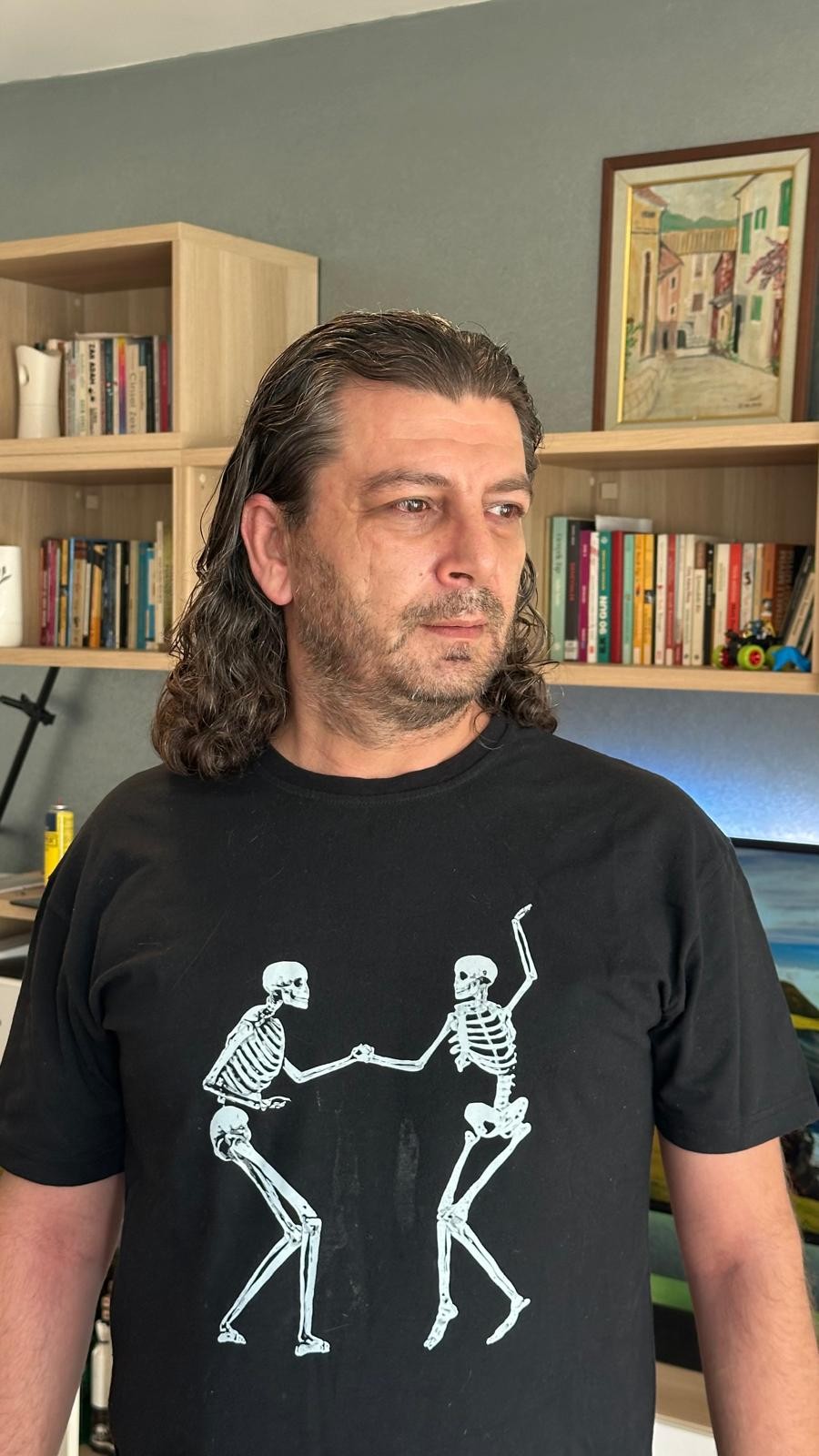 Altuğ Erbaşı kitaplığının önünde, düşünceli bir anında